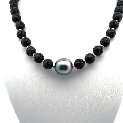 Kaia Lava Rock necklace featuring a central dark black Tahitian pearl accented by natural black lava stone beads on a gold-detailed strand.