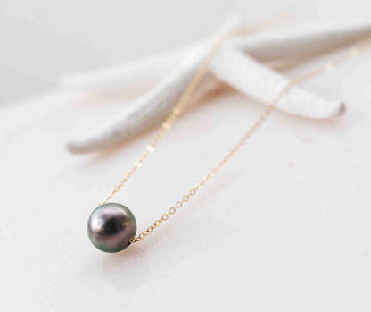 The Mo‘i Necklace featuring a single black  Tahitian pearl suspended on a delicate gold-filled chain.