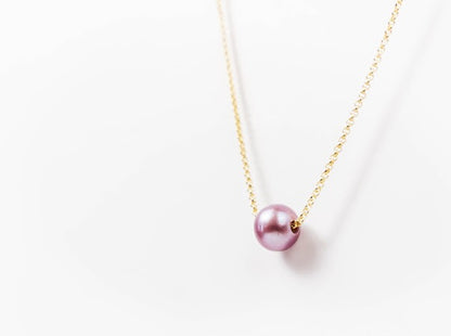 Single pink Edison pearl necklace on a delicate gold-filled chain against a white background.