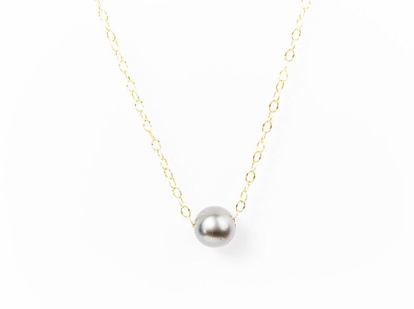 Silver Tahitian pearl necklace on a delicate gold-filled chain against a white background.