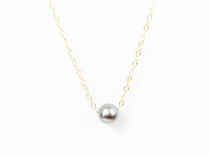 Silver Tahitian pearl necklace on a delicate gold-filled chain against a white background.