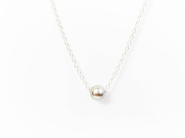 Silver Tahitian pearl necklace on a fine silver chain against a white background.