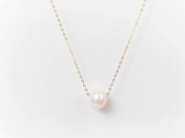 White Edison pearl necklace on a fine gold-filled chain against a white background.